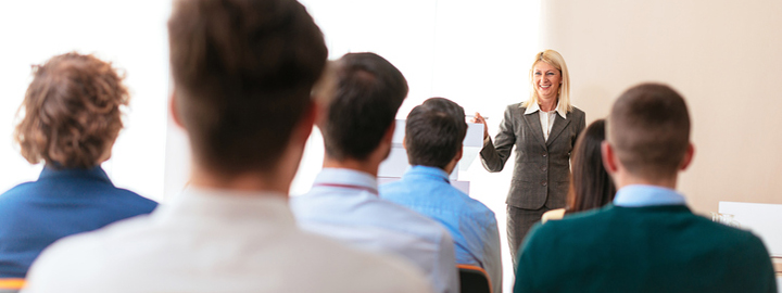 Image of large or medium group of people sitting in conference hall, and listening to public speaker, consultant, lecturer or professor, actively participating in the class by raising hands, clapping, voting or discussing. Image taken with Nikon D800 and 50 or 85mm lens, developed from RAW. Location: Europe