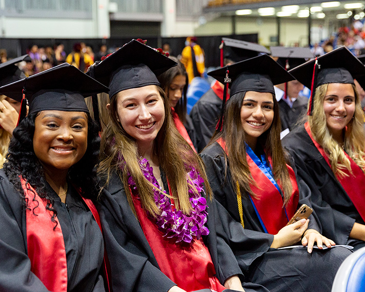 students in their caps and gowns at commencement