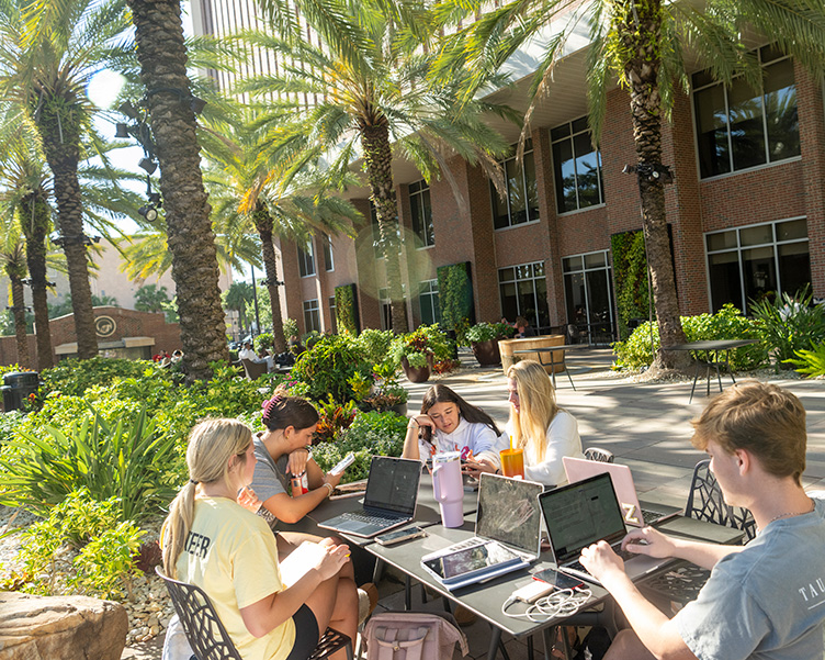 Students studying outside at a table together.