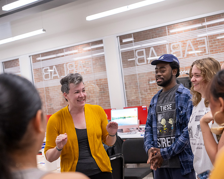 Professor and students discussing tasks in the Fab Lab.